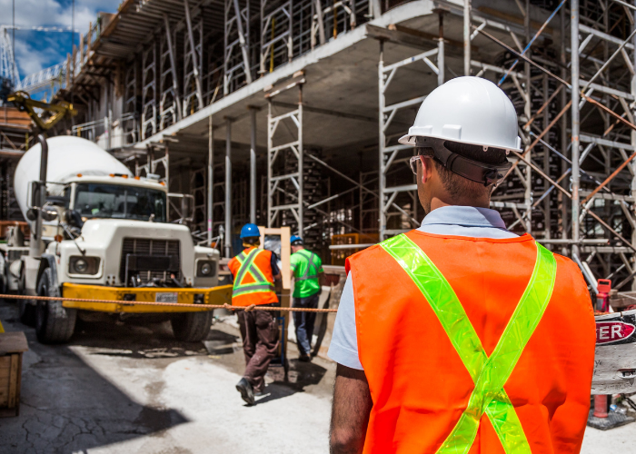 Site safety professionals in hard hats and high-visibility gear conducting safety oversight at construction project