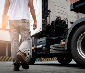 Commercial truck driver performing pre-trip safety inspection on transport vehicle
