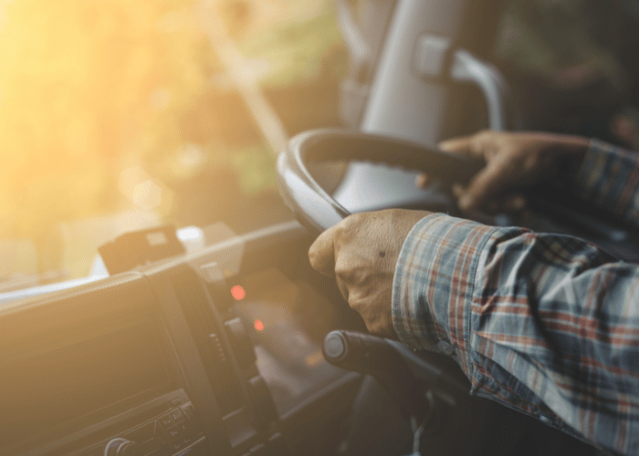Professional truck driver in cab using safety technology and communication systems