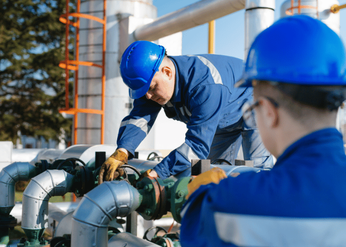Oil and gas workers in safety gear performing equipment maintenance and safety procedures