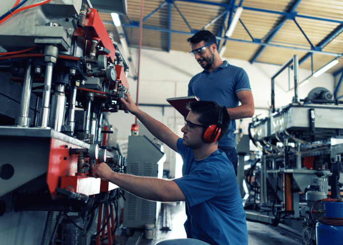 Manufacturing worker in safety gear operating industrial machinery and equipment