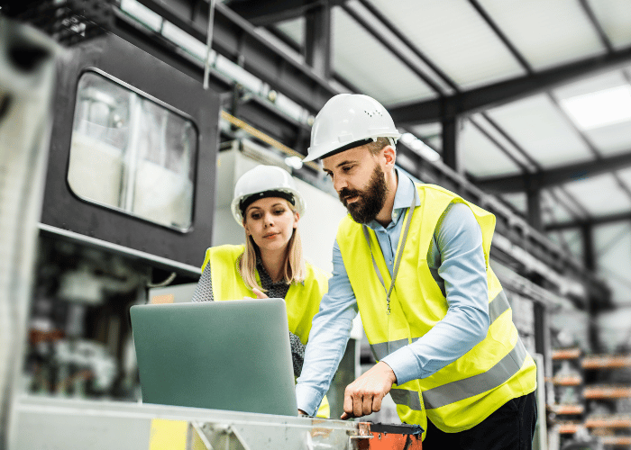 Manufacturing safety managers in high-visibility gear using digital safety technology